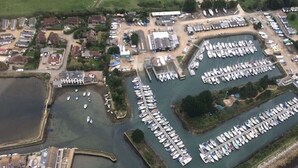 An aerial view of a marina with numerous boats docked, surrounded by residential buildings and a small body of water. - 'Crab Shack' Luxury Yurt with Harbour & Sea Views (Emsworth)