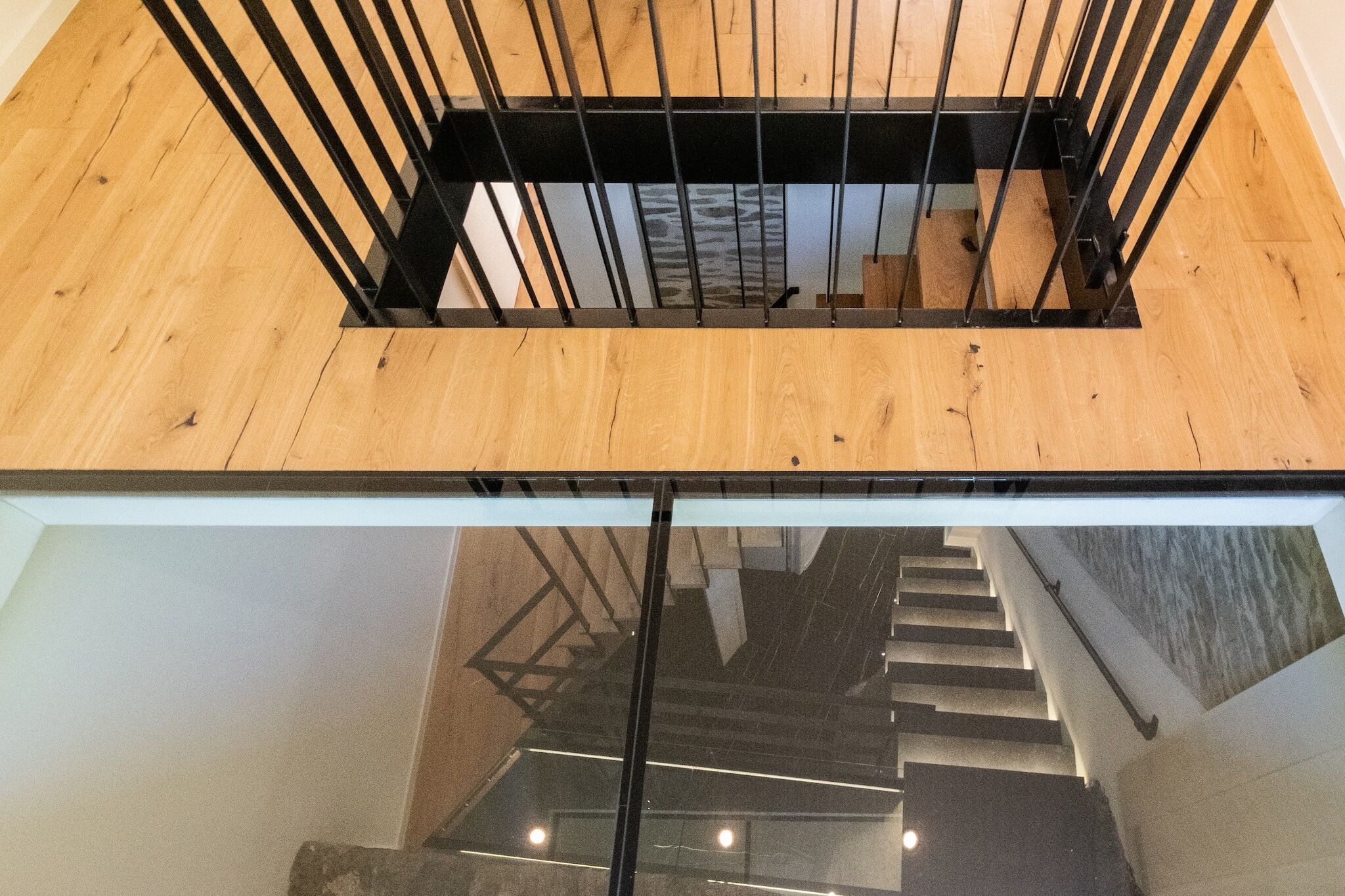 Eine moderne Treppe mit Holzvertäfelung und schwarzen Metallgeländern.
