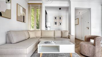 A modern living room with a sectional sofa, a white coffee table, and a patterned rug.