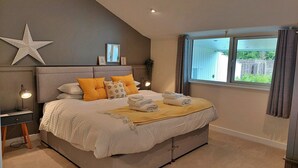A bedroom with a large bed, a star decoration, and a window with curtains.