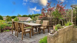 An outdoor patio with wooden furniture and a stone pathway. - Cottage in St Dennis near Eden Project (St Dennis)
