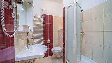Une salle de bain avec un lavabo, des toilettes et une douche.