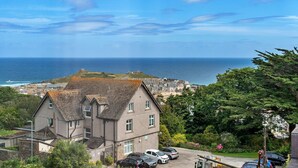Un bâtiment situé sur la côte, offrant une vue sur la mer et sur une ville en arrière-plan.