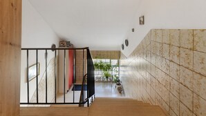 A staircase with a wooden handrail, tiled walls, and potted plants. - Holiday Apartment 'Hannelore' with Shared Garden, Balcony and Wi-Fi (Radolfzell am Bodensee)