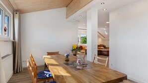 A dining area with a wooden table, chairs, and a vase of flowers. - Holiday Apartment 'Hannelore' with Shared Garden, Balcony and Wi-Fi (Radolfzell am Bodensee)