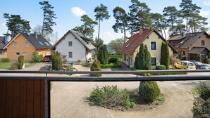 Et boligområde med huse, en asfalteret indkørsel og et vandareal i baggrunden.