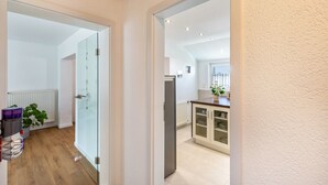 A modern kitchen with a refrigerator, cabinets, and a window. - Apartment 'New Look' with Mountain View, Balcony and Wi-Fi (Geisenheim)