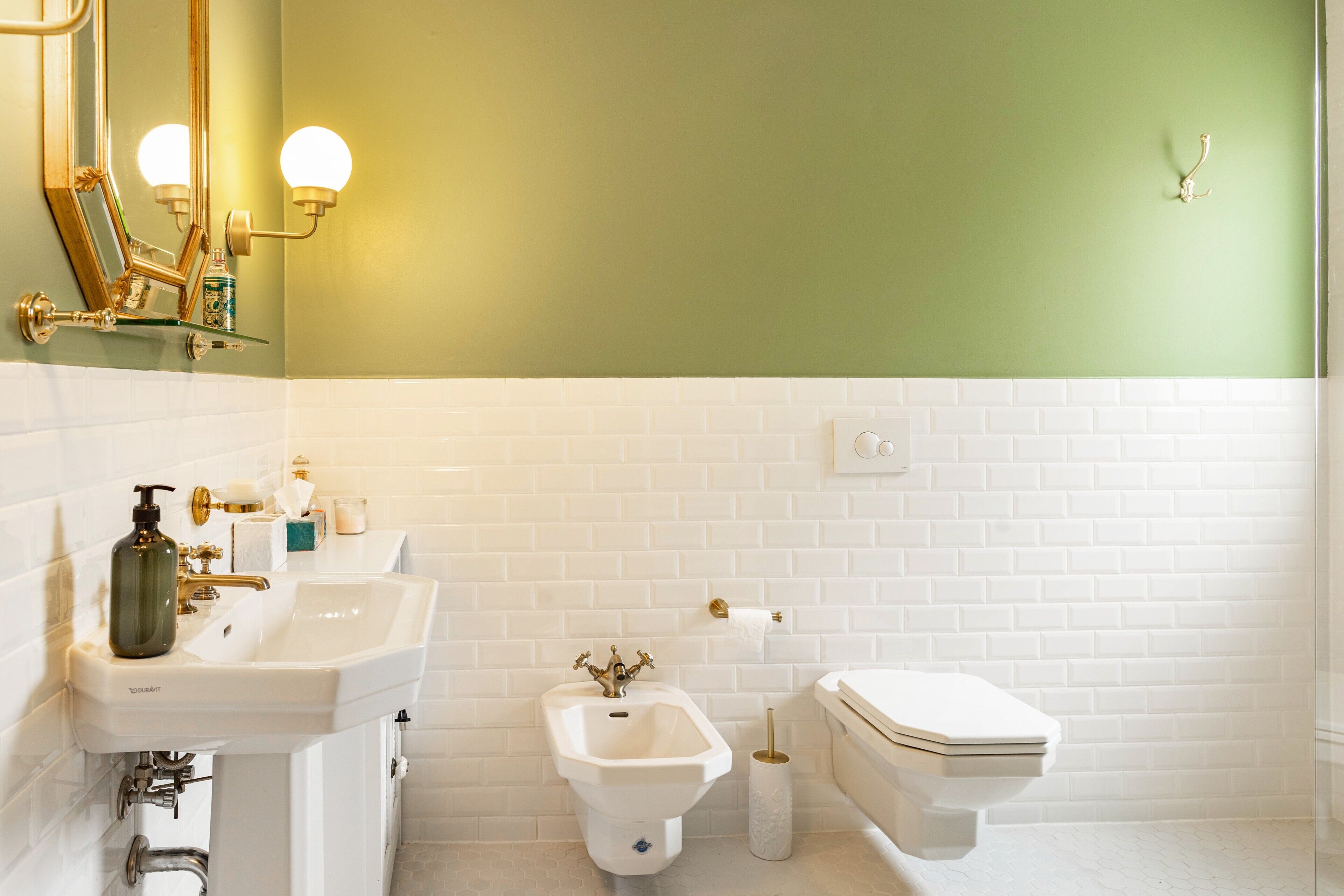 Un baño con un lavamanos blanco, un bidé y un inodoro.