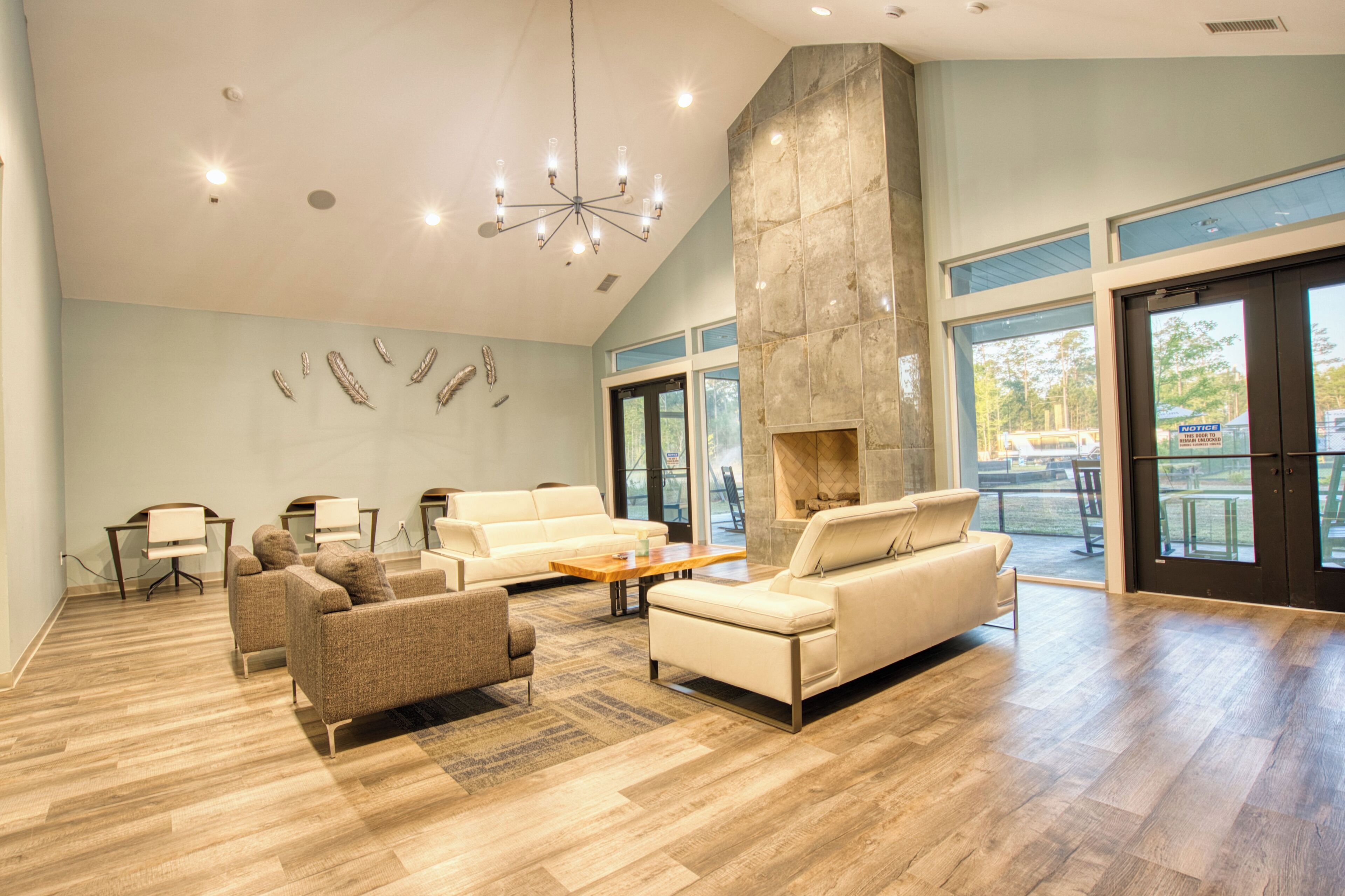 A spacious lobby with a high ceiling, a stone fireplace, and a seating area with sofas and armchairs.