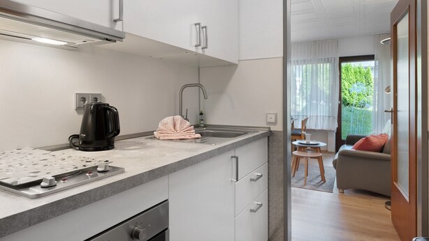 A modern kitchen with a coffee maker, a sink, and a towel on the counter. - Apartment 'Gertrud' with Shared Terrace and Shared Garden (Schönwald im Schwarzwald)