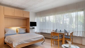 A bedroom with a bed, a desk, and a chair. - Apartment 'Gertrud' with Shared Terrace and Shared Garden (Schönwald im Schwarzwald)