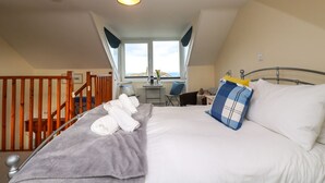 A bedroom with a bed, a desk, and a window. - Breakers Point (St Ives)