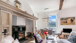 A living room with a fireplace, dining area, and a television. - Mica Aurea Morcote - Villa With Terrace (Morcote)