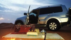 A silver SUV parked in a desert with a tent set up nearby. - Gite ditabe tafoukte  (Imi N'Oulaoune)