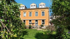 A two-story residential building with a flat roof, multiple windows, and a fenced yard. - Apartment 'Annemarie Galle' with Wi-Fi (Meißen)