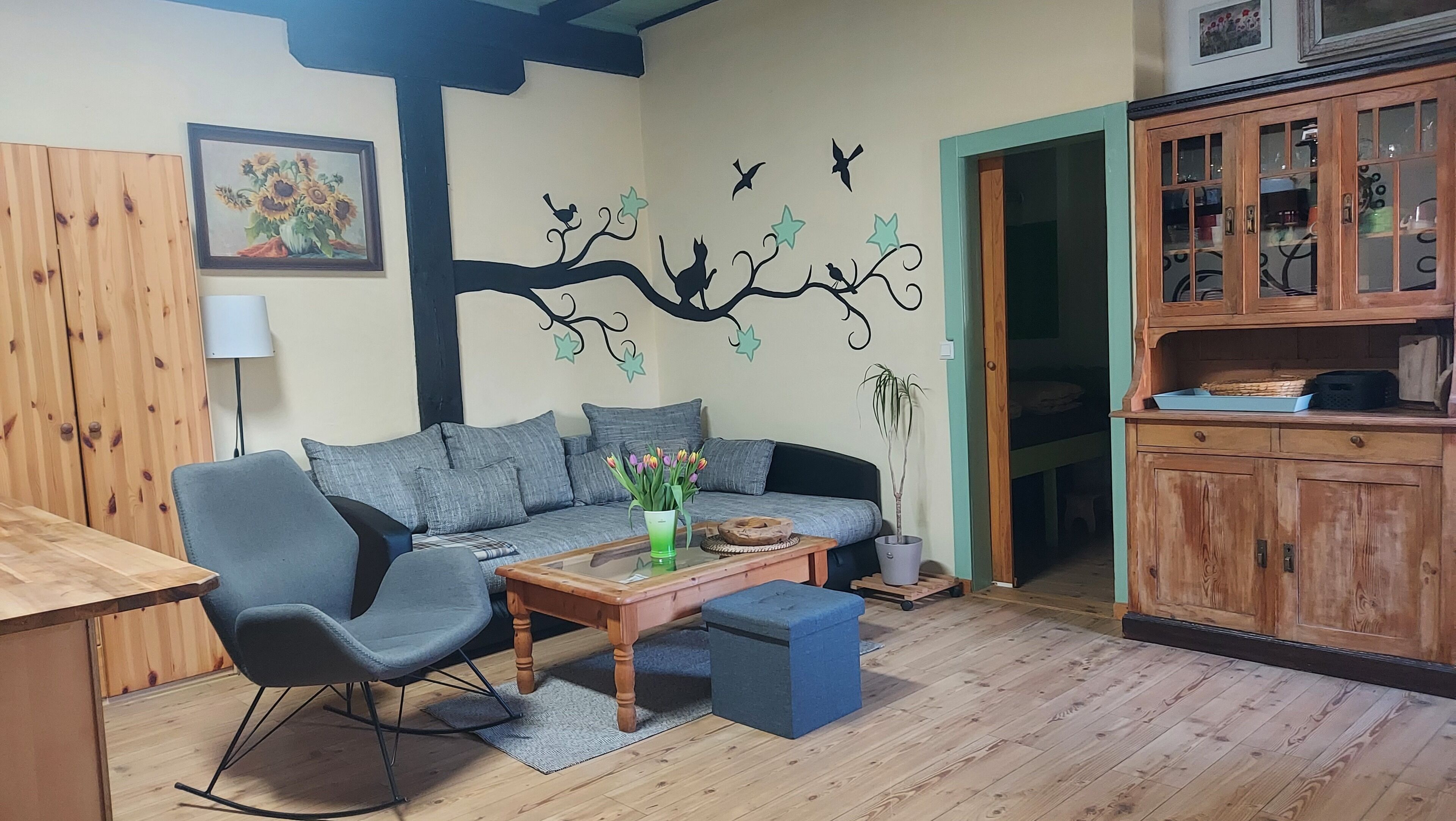 A cozy living room with a sofa, a wooden coffee table, and a blue ottoman.