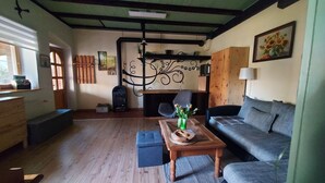 Una sala acogedora con sofá, una mesa de centro de madera, chimenea y un adorno en la pared.