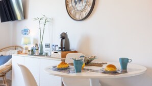 Ein Frühstückstisch mit Croissants, einer Kaffeetasse und einer Weltkarte als Wanduhr.