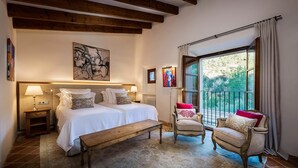 A bedroom with two beds, a bench, a chair, and a balcony with curtains.