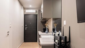 A modern bathroom with a dark door, white sinks, and a mirror. - WYZ Museum by UPSTREET (Athens)