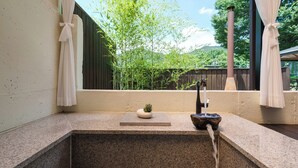 A bathroom with a stone sink, a small potted plant, and a bamboo fence in the background. - Boeun Pension at 77 Igashinjeong-gil (Boeun)