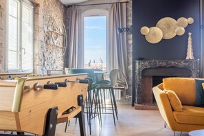 Une pièce avec une table de billard, une cheminée et une vue sur le paysage urbain.