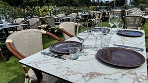Een eettafel klaar voor een maaltijd buiten, met stoelen en servies.
