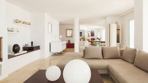 Un salon moderne avec un canapé beige, deux éléments de décoration sphériques blancs et un design minimaliste.