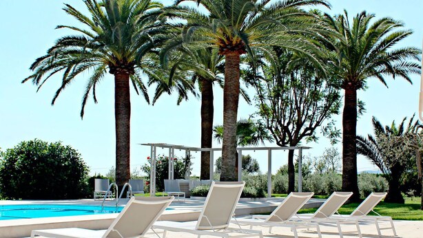 A poolside area with lounge chairs and palm trees. - My Rental Homes - Villa Acapulco private pool, barbeque and wifi (Palma De Mallorca)