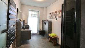 A compact bathroom with a toilet, sink, and a small stool. A "BATHROOM" sign is visible on the wall. - Island jewel in the Lindenhof with south-facing terrace (Wangerooge)