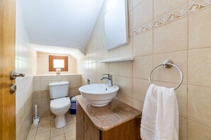 A bathroom with a toilet, sink, and towel rack. - Villa Sarah (Sotira)