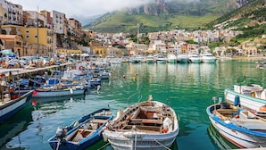 A coastal town with a marina filled with boats, buildings along the waterfront, and a mountainous backdrop. - Villa Zora with pool and garden - My Rental Homes (Syracuse)