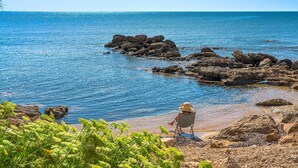 A rocky shoreline with clear blue water and greenery in the foreground. - Villa Zora with pool and garden - My Rental Homes (Syracuse)