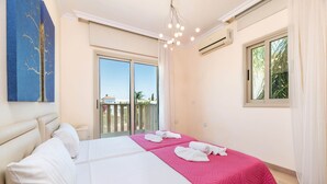 A hotel room with a bed, a balcony, and a view of the outside. - Villa Jacqueline (Paralimni)