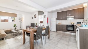 A modern apartment with a dining area, kitchen, and living space. - Napa Centro Apartment (Ayia Napa)
