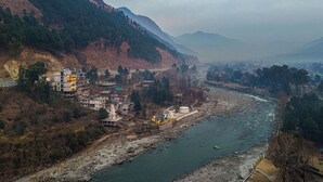 Une rivière qui traverse une région montagneuse, avec des bâtiments situés le long de ses rives.
