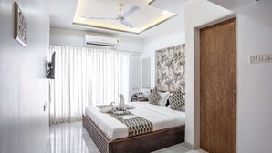 Un dormitorio moderno con una cama, un ventilador de techo y una puerta de madera.