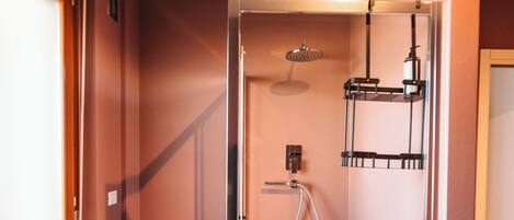 A modern bathroom with a glass-enclosed shower, a built-in sink, and a towel rack.