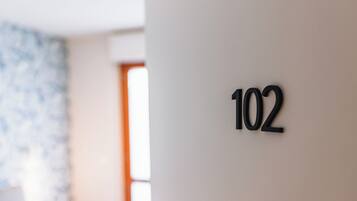 A close-up of a wall with the number 102, indicating a room or location within a building.