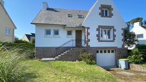 A two-story house with a sloped roof, a front entrance with a door, and a small front porch. - House 320m from the beach with garden in Trégastel (Trégastel)