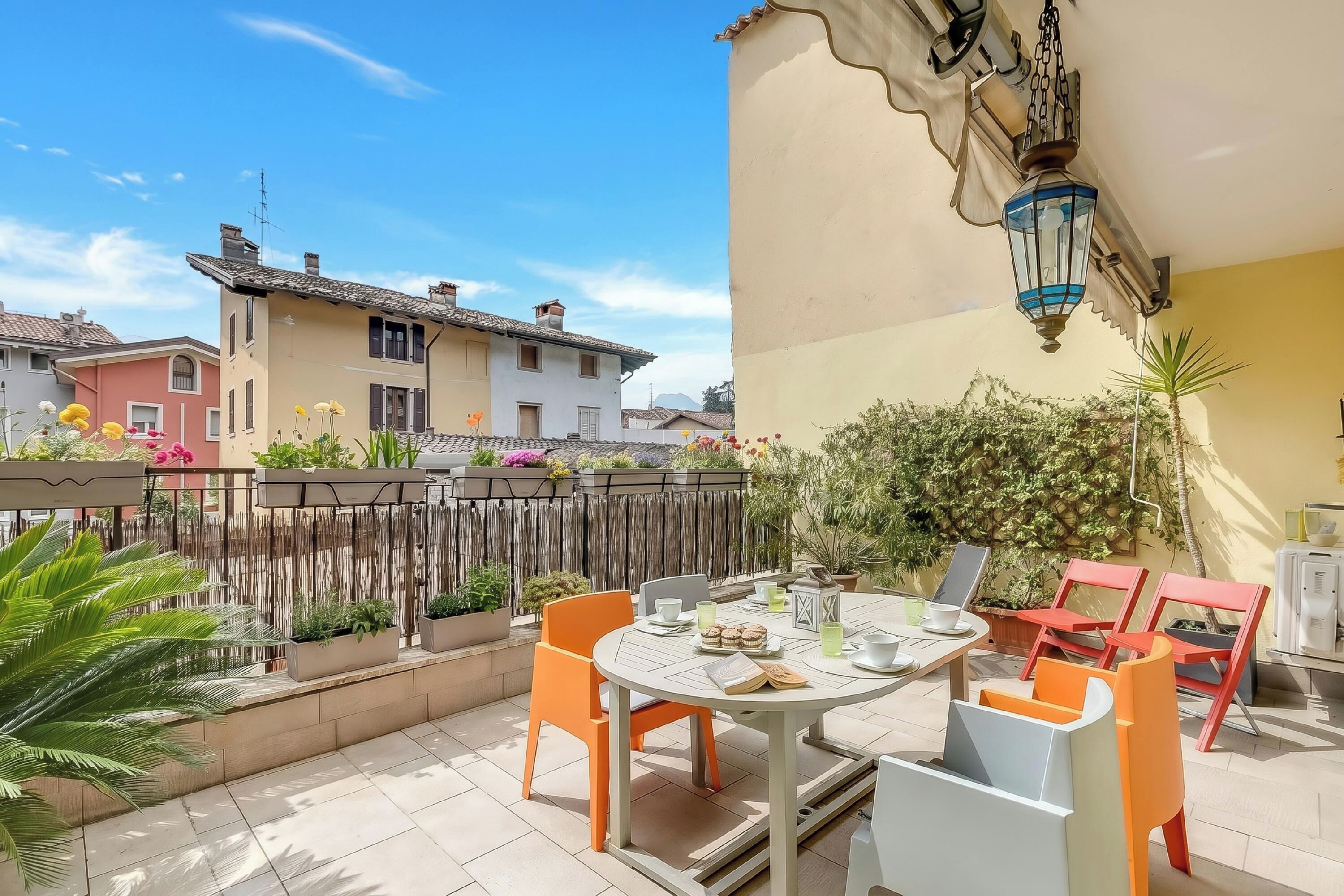 Eine Terrasse mit Tisch, Stühlen und einer Laterne.