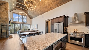 A spacious kitchen with granite countertops, stainless steel appliances, and a large island. - Camp Care Free at Eagles Nest - game room, hot tub, fire pit (Banner Elk)