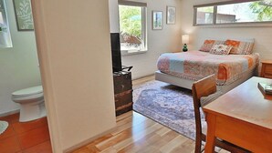 Un dormitorio con cama, escritorio, silla, cómoda y ventana.