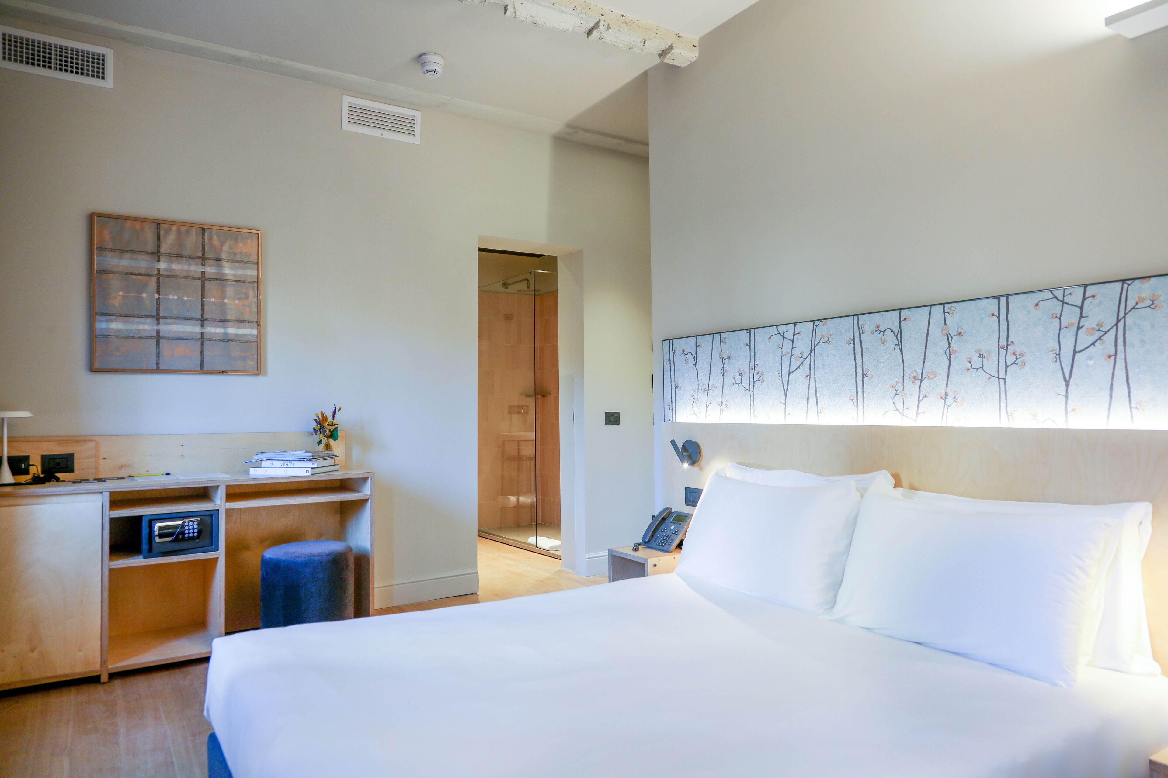 Una habitación de hotel con una cama grande, un escritorio con microondas y un teléfono.