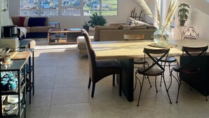 Un loft espaiós amb un gran lucernari, una zona de menjador i un espai tranquil per seure amb vistes al barri.