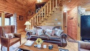 A wooden interior with a sofa, armchairs, and a coffee table.