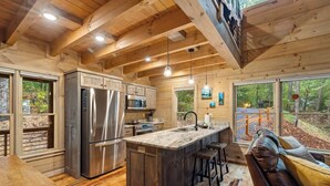 Una cucina moderna con una grande isola, elettrodomestici in acciaio inossidabile e mobili in legno.
