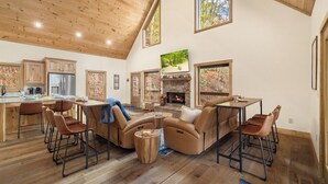 A spacious living area with a fireplace, a dining table, and comfortable seating.