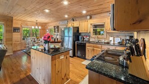 Una cocina amplia con armarios de madera, una isla central y vistas al exterior.