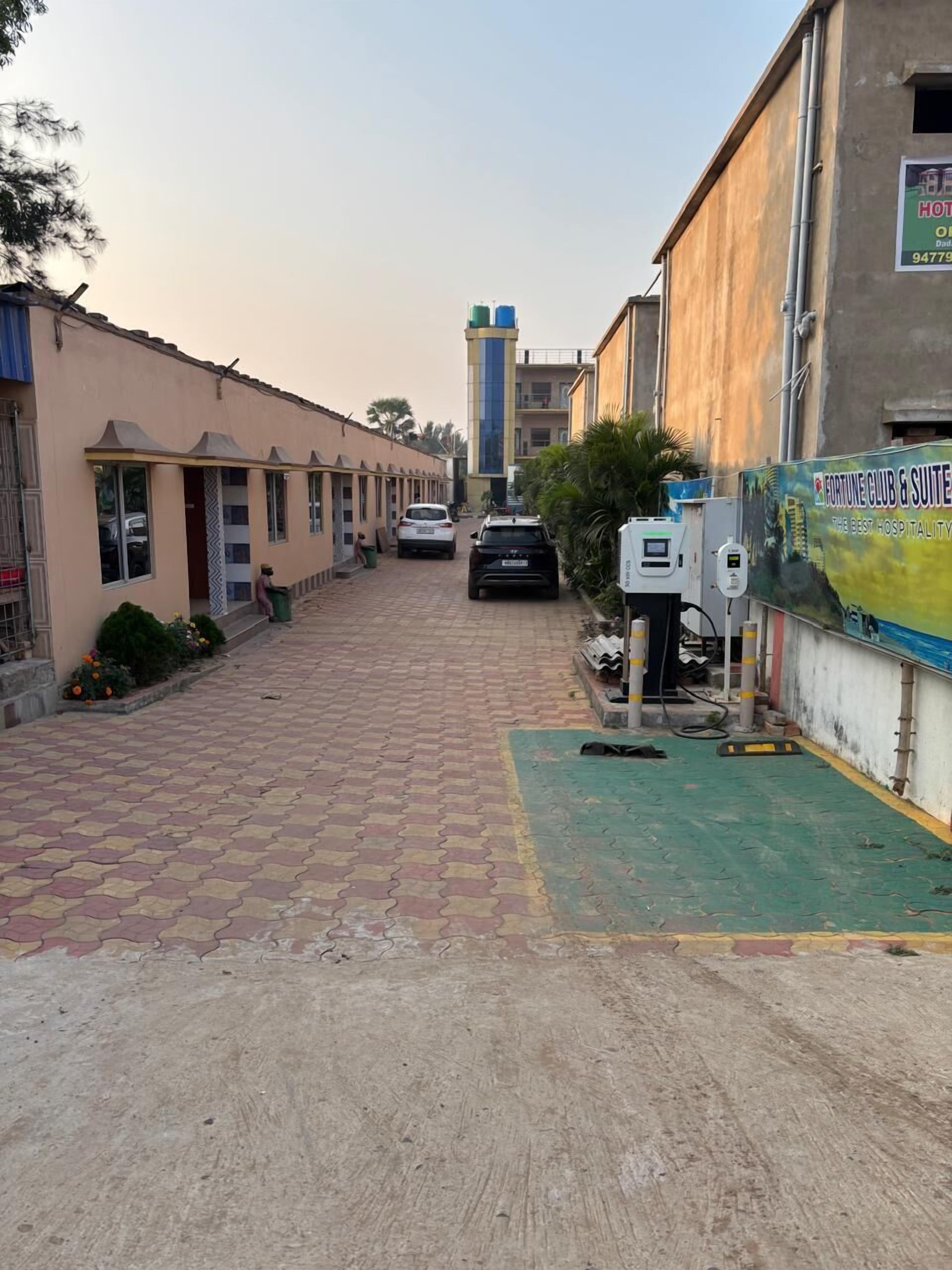 A hotel corridor with a tiled floor, a parked car, and a building with a sign for a hotel and a club.